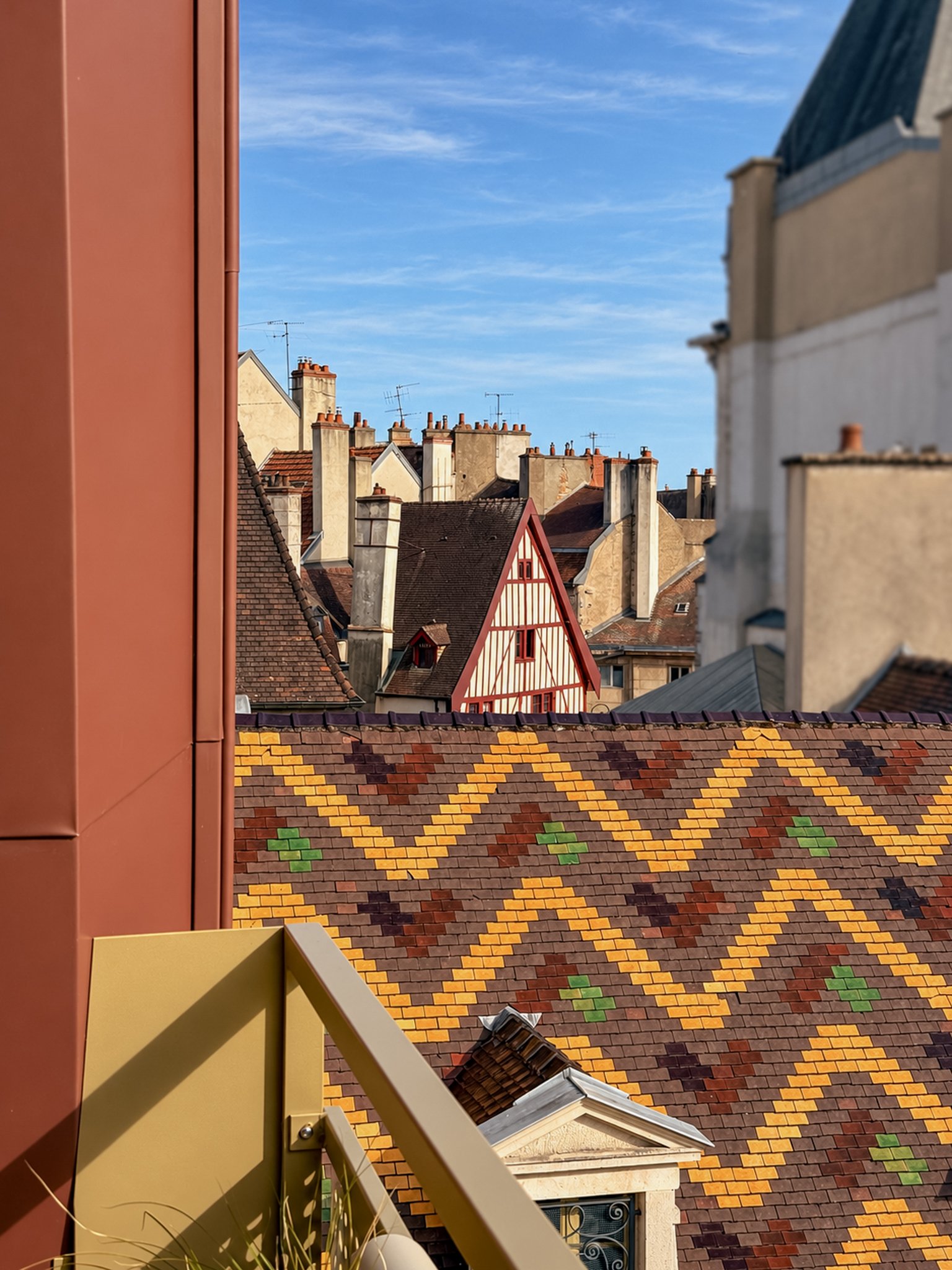 Mur bordeaux de l'agence et applique dorée au-dessus du plan en pierre