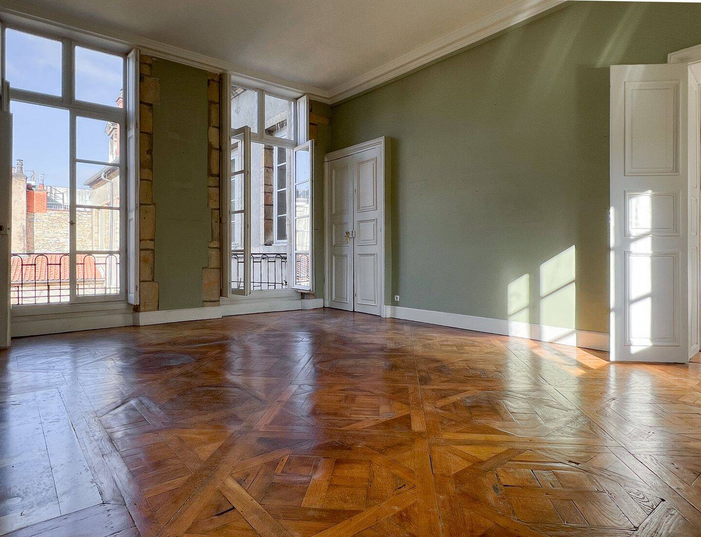 Pièce d'angle traversante et ses hautes fenêtres, parquet marqueté